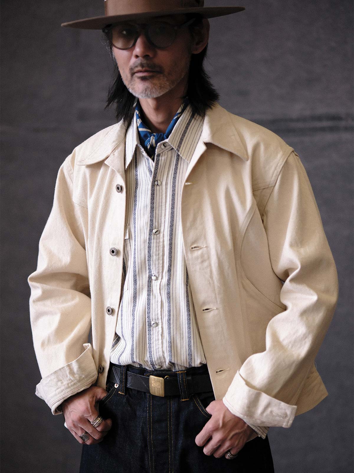 詳細画像:
赤耳部分のディテールと金属ボタンのクローズアップ。高級感を引き立てる赤耳デザインと精緻な金属ボタンが、ヴィンテージスタイルを際立たせます。
モデル画像:
モデルが生地の色赤耳デニムジャケットを着用し、カーゴパンツと合わせてアメリカンヴィンテージスタイルを披露。