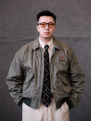 詳細画像:
TALONメタルジッパーとマジックテープエンブレムのディテール。レトロ感あふれるエンブレムとジッパーが、クラシックなフライトジャケットの魅力を引き立てます。
モデル画像:
モデルがCWU-45Pフライトジャケットを着用し、ジーンズやカーゴパンツと合わせたクラシックなミリタリースタイルを披露している画像。