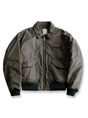 製品画像:
CWU-45Pフライトジャケット全体展示。高密度ナイロン素材と厚手のキルティング綿を使用し、ミリタリースタイルと快適性を兼ね備えたクラシックなデザイン。
詳細画像:
TALONメタルジッパーとマジックテープエンブレムのディテール。レトロ感あふれるエンブレムとジッパーが、クラシックなフライトジャケットの魅力を引き立てます。