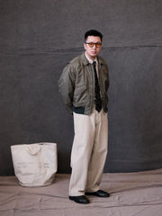 詳細画像:
TALONメタルジッパーとマジックテープエンブレムのディテール。レトロ感あふれるエンブレムとジッパーが、クラシックなフライトジャケットの魅力を引き立てます。
モデル画像:
モデルがCWU-45Pフライトジャケットを着用し、ジーンズやカーゴパンツと合わせたクラシックなミリタリースタイルを披露している画像。