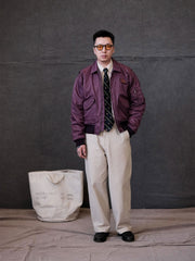 詳細画像:
TALONメタルジッパーとマジックテープエンブレムのディテール。フラップポケットやリブ編みの袖口、裾など、ミリタリーウェア特有のデザインが強調された画像。
モデル画像:
モデルがCWU-45Pフライトジャケットを着用し、ジーンズやカーゴパンツと組み合わせて、クラシックなミリタリースタイルを披露している画像。