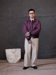 詳細画像:
TALONメタルジッパーとマジックテープエンブレムのディテール。フラップポケットやリブ編みの袖口、裾など、ミリタリーウェア特有のデザインが強調された画像。
モデル画像:
モデルがCWU-45Pフライトジャケットを着用し、ジーンズやカーゴパンツと組み合わせて、クラシックなミリタリースタイルを披露している画像。