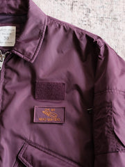 製品画像:
CWU-45Pフライトジャケットの全体展示。高密度ナイロン外層と厚手のキルティング綿を使用した、保温性と防風性に優れたクラシックなフライトジャケットの全体像。
詳細画像:
TALONメタルジッパーとマジックテープエンブレムのディテール。フラップポケットやリブ編みの袖口、裾など、ミリタリーウェア特有のデザインが強調された画像。