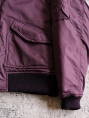 製品画像:
CWU-45Pフライトジャケットの全体展示。高密度ナイロン外層と厚手のキルティング綿を使用した、保温性と防風性に優れたクラシックなフライトジャケットの全体像。
詳細画像:
TALONメタルジッパーとマジックテープエンブレムのディテール。フラップポケットやリブ編みの袖口、裾など、ミリタリーウェア特有のデザインが強調された画像。