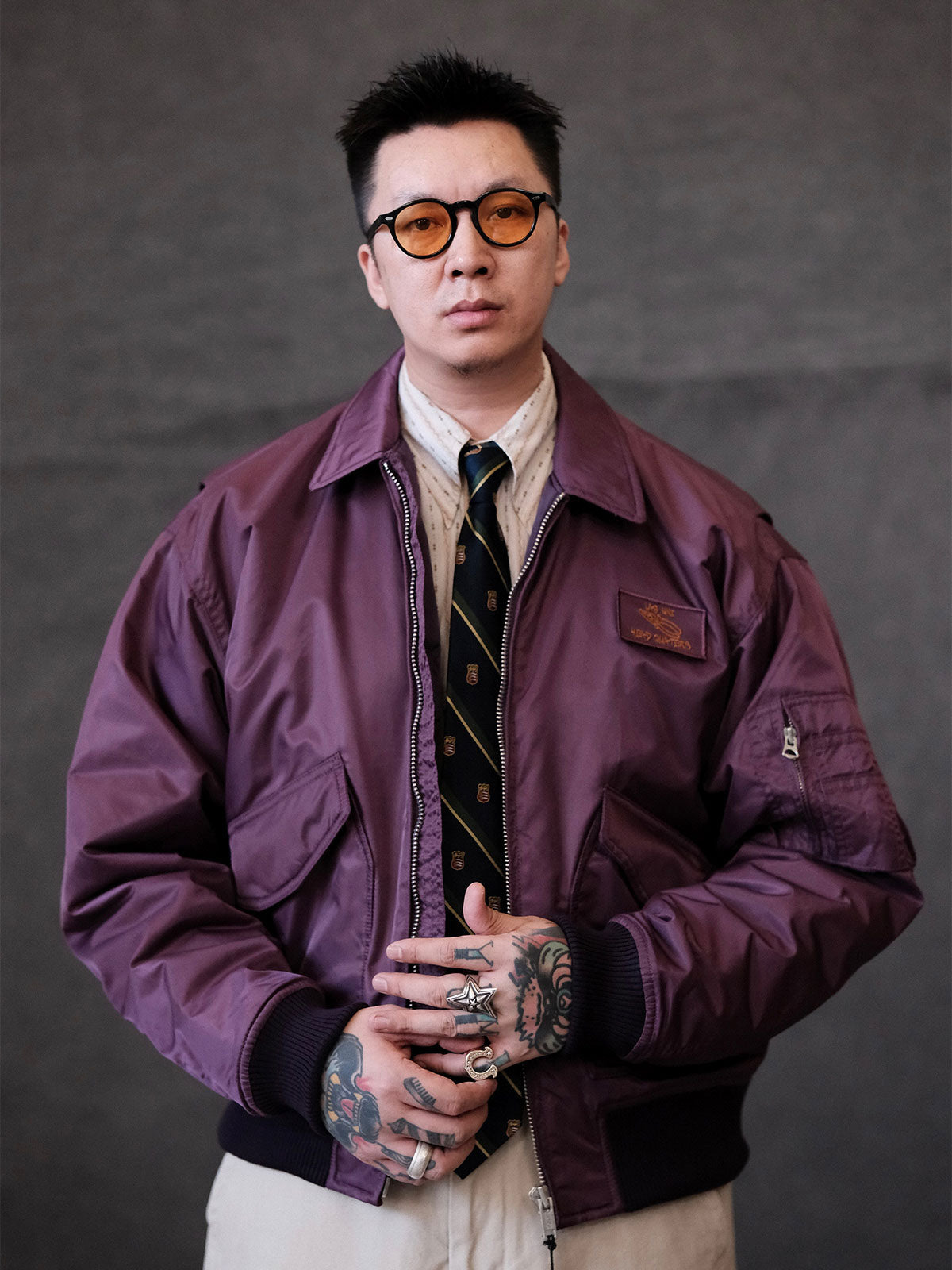 詳細画像:
TALONメタルジッパーとマジックテープエンブレムのディテール。フラップポケットやリブ編みの袖口、裾など、ミリタリーウェア特有のデザインが強調された画像。
モデル画像:
モデルがCWU-45Pフライトジャケットを着用し、ジーンズやカーゴパンツと組み合わせて、クラシックなミリタリースタイルを披露している画像。