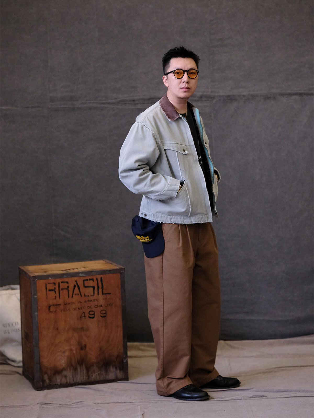 詳細画像:
TALONジッパー、スナップボタン、及び水洗い加工のディテール。多重水洗い加工と手作業のダメージ加工が施された、ヴィンテージ感が強調されたディテール。
モデル画像:
モデルがリバイバルキャンバスジャケットを着用し、カーゴパンツと合わせてアメリカンリバイバルスタイルを演出している画像。