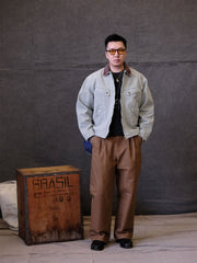 詳細画像:
TALONジッパー、スナップボタン、及び水洗い加工のディテール。多重水洗い加工と手作業のダメージ加工が施された、ヴィンテージ感が強調されたディテール。
モデル画像:
モデルがリバイバルキャンバスジャケットを着用し、カーゴパンツと合わせてアメリカンリバイバルスタイルを演出している画像。