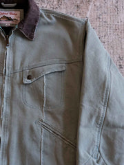 製品画像:
リバイバルダメージパッチワークキャンバスジャケット全体展示。15ozの定織キャンバスと日本製厚ウール裏地を使用し、ヴィンテージスタイルを引き立てるタフなキャンバスジャケットの全体像。
詳細画像:
TALONジッパー、スナップボタン、及び水洗い加工のディテール。多重水洗い加工と手作業のダメージ加工が施された、ヴィンテージ感が強調されたディテール。