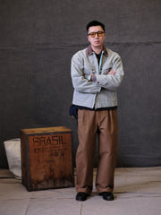 詳細画像:
TALONジッパー、スナップボタン、及び水洗い加工のディテール。多重水洗い加工と手作業のダメージ加工が施された、ヴィンテージ感が強調されたディテール。
モデル画像:
モデルがリバイバルキャンバスジャケットを着用し、カーゴパンツと合わせてアメリカンリバイバルスタイルを演出している画像。