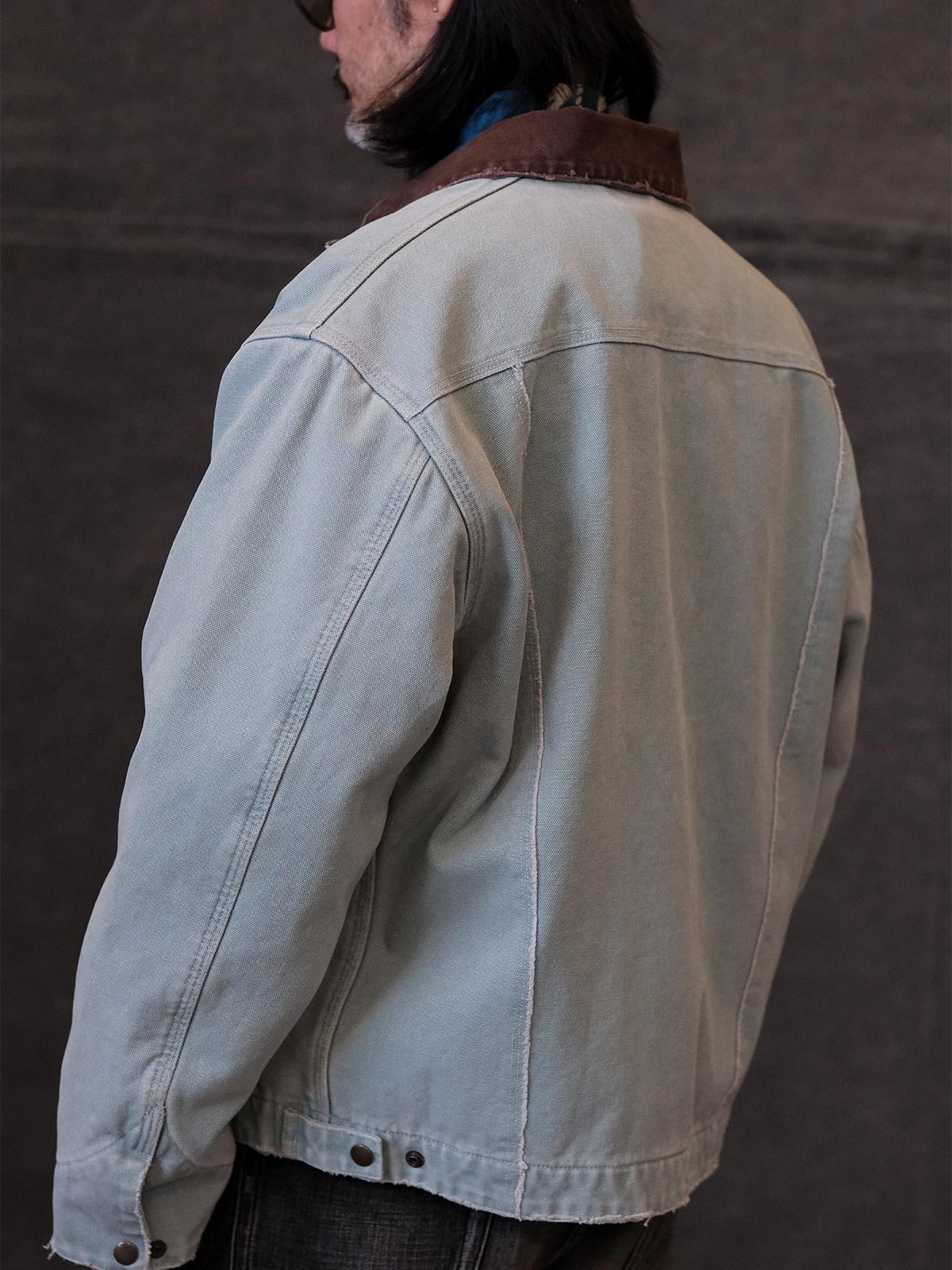 詳細画像:
TALONジッパー、スナップボタン、及び水洗い加工のディテール。多重水洗い加工と手作業のダメージ加工が施された、ヴィンテージ感が強調されたディテール。
モデル画像:
モデルがリバイバルキャンバスジャケットを着用し、カーゴパンツと合わせてアメリカンリバイバルスタイルを演出している画像。