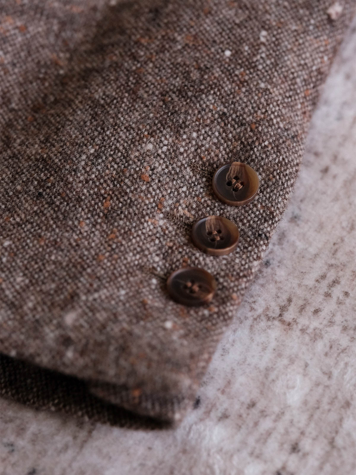 製品画像:
リバイバルカラードットウールツイードスーツジャケット全体展示。530gウールツイード生地とカラードットデザインで、1930年代のクラシックスタイルを現代的に再現したスーツジャケットの全体像。
詳細画像:
ツイード模様とカラードットデザインのディテール。リバイバル感を強調するために精緻なテクスチャーとカスタムボタンが施されたディテール。
