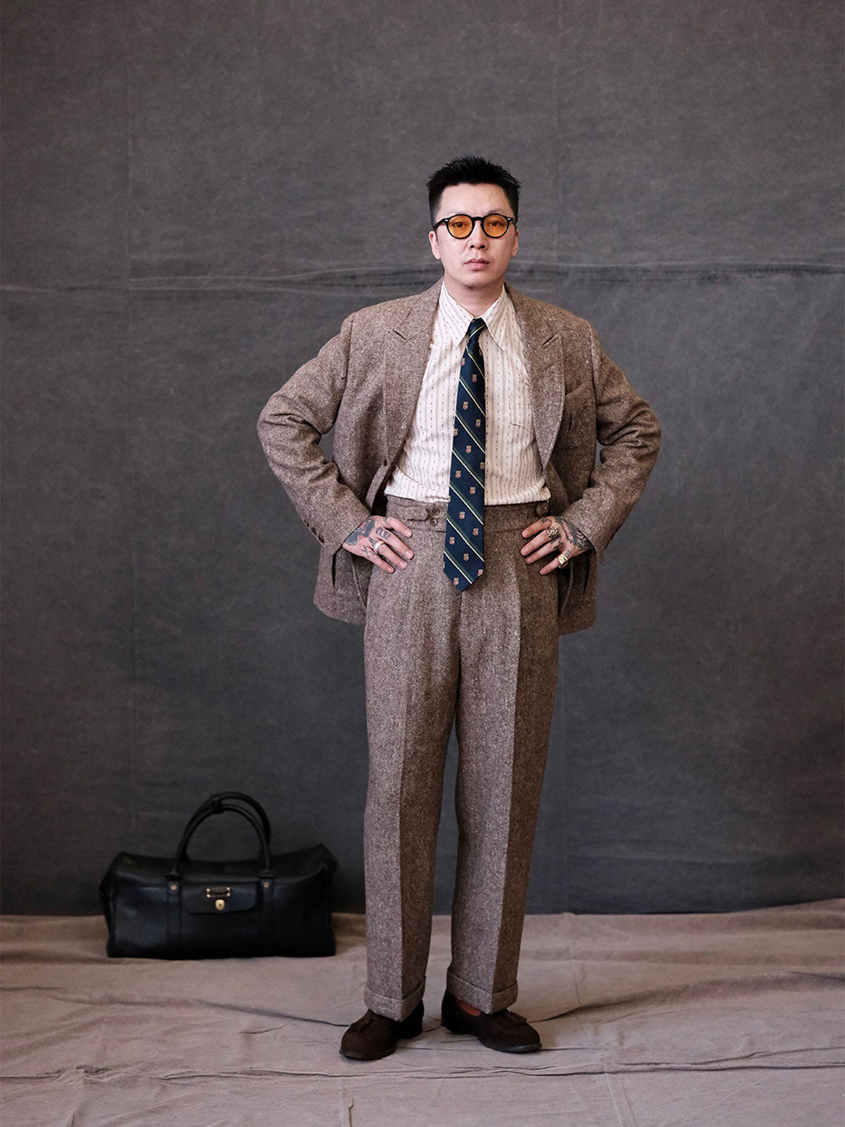 詳細画像:
ウールツイード生地とカラードットディテールのクローズアップ。細かなカラードットとテクスチャーが強調され、ヴィンテージスタイルの視覚効果を引き出しているディテール。
モデル画像:
モデルがヴィンテージウールツイードスラックスを着用し、スーツジャケットやウールジャケットとのコーディネートでアメリカンフォーマルスタイルを披露している画像。