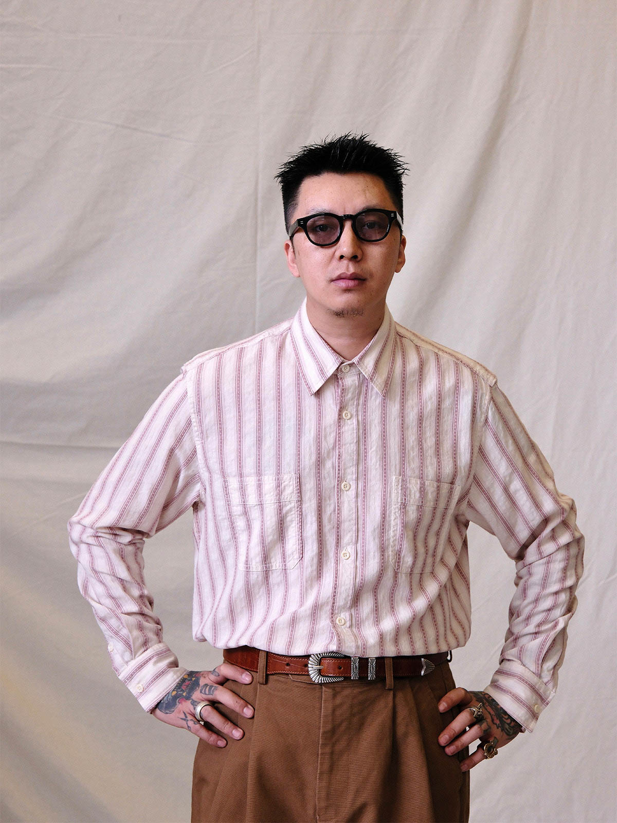 詳細画像:
エッチング加工された真鍮バックルのディテール。精緻な彫刻が施された立体感のあるバックルが、ヴィンテージスタイルの魅力を引き立てるディテール。
モデル画像:
モデルがヴィンテージキャバルリーベルトを着用し、デニムやカーゴパンツと合わせて、アメリカンウェスタンスタイルを披露している画像。