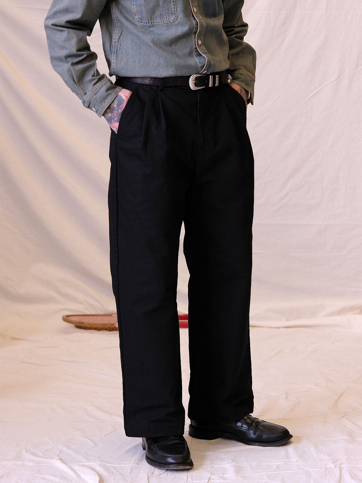 詳細画像:
エッチング加工された真鍮バックルのディテール。精緻な彫刻が施された立体感のあるバックルが、ヴィンテージスタイルの魅力を引き立てるディテール。
モデル画像:
モデルがヴィンテージキャバルリーベルトを着用し、デニムやカーゴパンツと合わせて、アメリカンウェスタンスタイルを披露している画像。