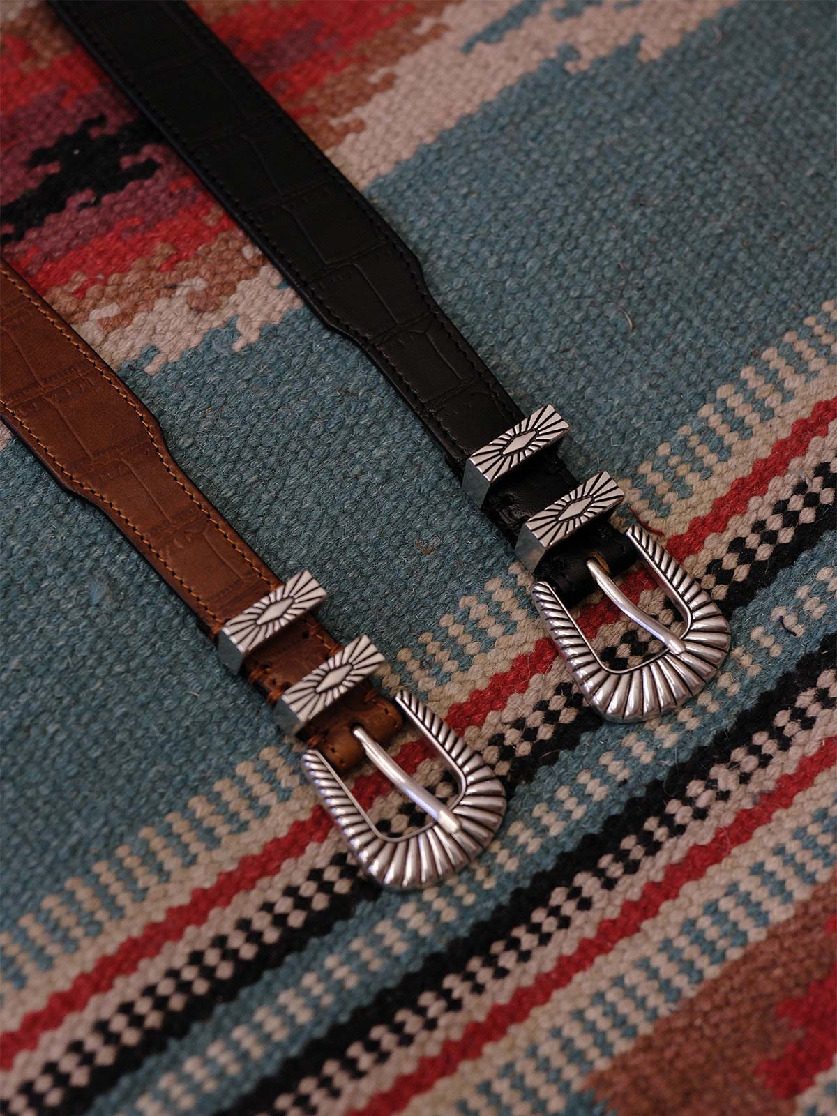 製品画像:
ヴィンテージキャバルリー インポートレザーベルト全景展示。アメリカンウェスタンスタイルにインスパイアされたインポートレザー素材のベルトで、タフでレトロなヴィンテージ感が表現された全体像。
詳細画像:
エッチング加工された真鍮バックルのディテール。精緻な彫刻が施された立体感のあるバックルが、ヴィンテージスタイルの魅力を引き立てるディテール。