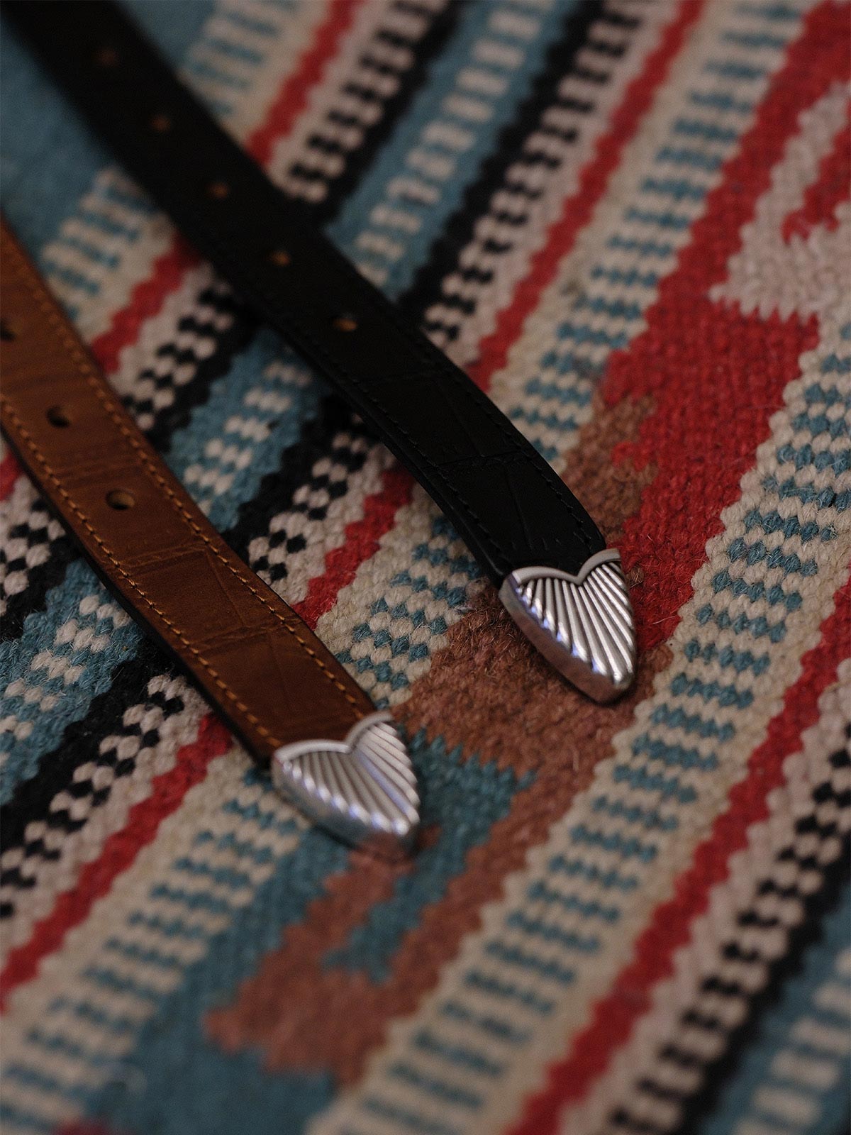 製品画像:
ヴィンテージキャバルリー インポートレザーベルト全景展示。アメリカンウェスタンスタイルにインスパイアされたインポートレザー素材のベルトで、タフでレトロなヴィンテージ感が表現された全体像。
詳細画像:
エッチング加工された真鍮バックルのディテール。精緻な彫刻が施された立体感のあるバックルが、ヴィンテージスタイルの魅力を引き立てるディテール。