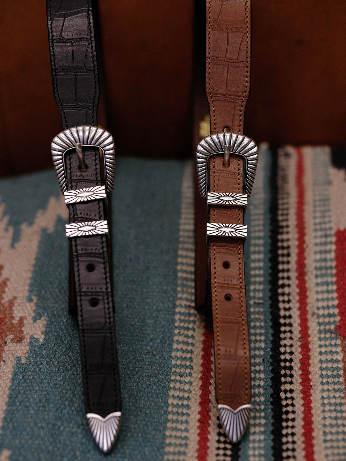 製品画像:
ヴィンテージキャバルリー インポートレザーベルト全景展示。アメリカンウェスタンスタイルにインスパイアされたインポートレザー素材のベルトで、タフでレトロなヴィンテージ感が表現された全体像。
詳細画像:
エッチング加工された真鍮バックルのディテール。精緻な彫刻が施された立体感のあるバックルが、ヴィンテージスタイルの魅力を引き立てるディテール。