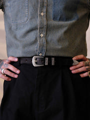 詳細画像:
エッチング加工された真鍮バックルのディテール。精緻な彫刻が施された立体感のあるバックルが、ヴィンテージスタイルの魅力を引き立てるディテール。
モデル画像:
モデルがヴィンテージキャバルリーベルトを着用し、デニムやカーゴパンツと合わせて、アメリカンウェスタンスタイルを披露している画像。