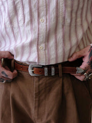 詳細画像:
エッチング加工された真鍮バックルのディテール。精緻な彫刻が施された立体感のあるバックルが、ヴィンテージスタイルの魅力を引き立てるディテール。
モデル画像:
モデルがヴィンテージキャバルリーベルトを着用し、デニムやカーゴパンツと合わせて、アメリカンウェスタンスタイルを披露している画像。
