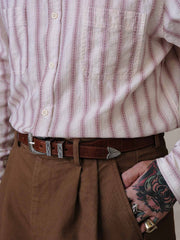 詳細画像:
エッチング加工された真鍮バックルのディテール。精緻な彫刻が施された立体感のあるバックルが、ヴィンテージスタイルの魅力を引き立てるディテール。
モデル画像:
モデルがヴィンテージキャバルリーベルトを着用し、デニムやカーゴパンツと合わせて、アメリカンウェスタンスタイルを披露している画像。