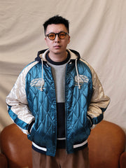 詳細画像:
精緻な刺繍と光沢サテン生地のディテール。大面積の刺繍デザインと鮮やかな色合いが、ジャケットに強い視覚的インパクトを与えるディテール。
モデル画像:
モデルがスカジョンジャケットを着用し、ジーンズやカーゴパンツと合わせて、クラシックなヴィンテージスタイルを披露している画像。