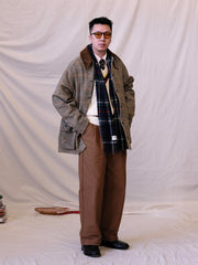 詳細画像:
ツイスト編みの編み目とカラーコンビネーションストライプのディテール。Vネックとストライプデザインが加える視覚的なレイヤード感を強調した画像。
モデル画像:
モデルがシャツと重ね着したVネック クリケットニットベストを着用し、英国風のアカデミックスタイルを演出している画像。