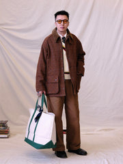 詳細画像:
ツイスト編みの編み目とカラーコンビネーションストライプのディテール。Vネックとストライプデザインが加える視覚的なレイヤード感を強調した画像。
モデル画像:
モデルがシャツと重ね着したVネック クリケットニットベストを着用し、英国風のアカデミックスタイルを演出している画像。