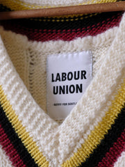 製品画像:
アカデミックスタイルVネック クリケットニットベストの全体展示。クラシックなツイスト編みとストライプデザインが特徴的な、100%ウール素材を使用したVネックデザインのニットベスト。
詳細画像:
ツイスト編みの編み目とカラーコンビネーションストライプのディテール。Vネックとストライプデザインが加える視覚的なレイヤード感を強調した画像。