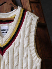 製品画像:
アカデミックスタイルVネック クリケットニットベストの全体展示。クラシックなツイスト編みとストライプデザインが特徴的な、100%ウール素材を使用したVネックデザインのニットベスト。
詳細画像:
ツイスト編みの編み目とカラーコンビネーションストライプのディテール。Vネックとストライプデザインが加える視覚的なレイヤード感を強調した画像。