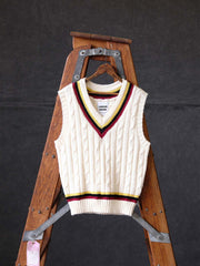 製品画像:
アカデミックスタイルVネック クリケットニットベストの全体展示。クラシックなツイスト編みとストライプデザインが特徴的な、100%ウール素材を使用したVネックデザインのニットベスト。
詳細画像:
ツイスト編みの編み目とカラーコンビネーションストライプのディテール。Vネックとストライプデザインが加える視覚的なレイヤード感を強調した画像。