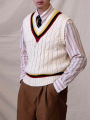 詳細画像:
ツイスト編みの編み目とカラーコンビネーションストライプのディテール。Vネックとストライプデザインが加える視覚的なレイヤード感を強調した画像。
モデル画像:
モデルがシャツと重ね着したVネック クリケットニットベストを着用し、英国風のアカデミックスタイルを演出している画像。