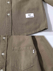 コットンワークシャツのディテールに焦点を当てたクローズアップ。柔らかな肌触りと洗練されたボタン使いが見える。