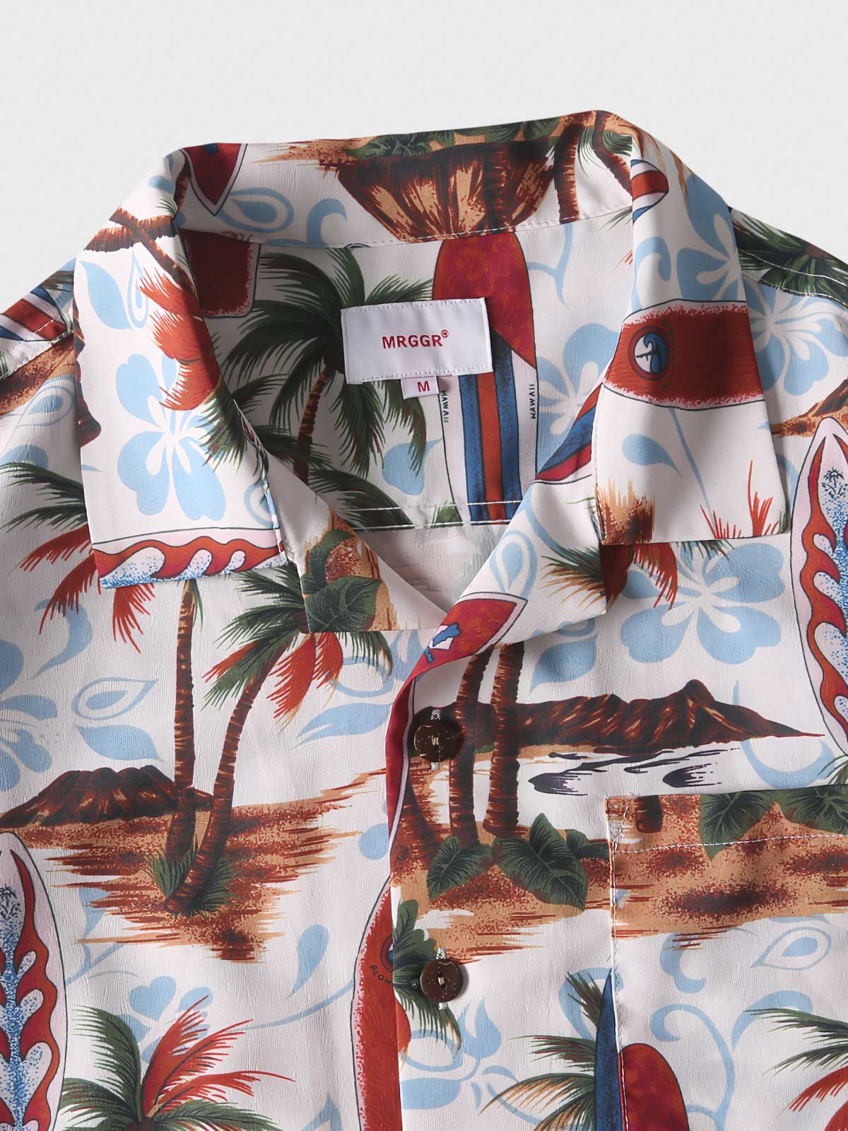 トロピカルプリント半袖シャツのディテールクローズアップ。精密なプリントとフロントポケットのデザインが特徴で、夏の装いに洗練されたタッチを加えます。