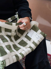 製品画像: ミリタリーテイストのショルダーバッグの全体展示
詳細画像: テントファブリックとウェビングのディテール
モデル画像: モデルが着用したミリタリーショルダーバッグのスタイリング例