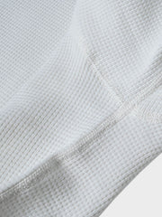 長袖Tシャツのワッフル格子テクスチャーのクローズアップ、外観の質感と衣服の吸湿性と保温性を強調。