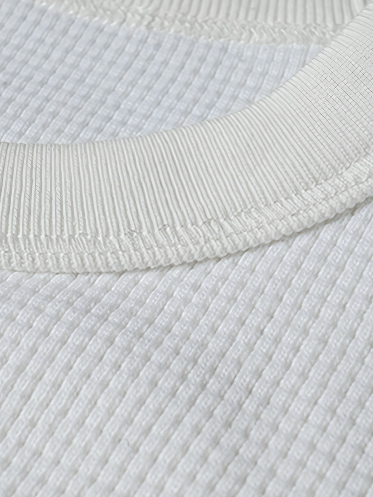 長袖Tシャツのワッフル格子テクスチャーのクローズアップ、外観の質感と衣服の吸湿性と保温性を強調。