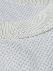 長袖Tシャツのワッフル格子テクスチャーのクローズアップ、外観の質感と衣服の吸湿性と保温性を強調。