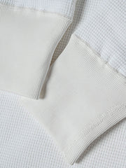 長袖Tシャツのワッフル格子テクスチャーのクローズアップ、外観の質感と衣服の吸湿性と保温性を強調。