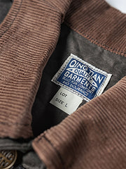 製品画像
19世紀末の防水技術を受け継いだイギリス ワックスド ワークジャケットの正面デザイン。ワックス加工を施した高密度コットンキャンバス生地とクラシックなラグランスリーブシルエットが特徴的
詳細画像
ブラウンのコーデュロイ襟とワックス加工特有のシワが際立つディテール。防風性と経年変化による質感の深みが魅力的なデザイン