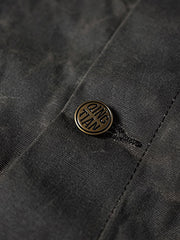 製品画像
19世紀末の防水技術を受け継いだイギリス ワックスド ワークジャケットの正面デザイン。ワックス加工を施した高密度コットンキャンバス生地とクラシックなラグランスリーブシルエットが特徴的
詳細画像
ブラウンのコーデュロイ襟とワックス加工特有のシワが際立つディテール。防風性と経年変化による質感の深みが魅力的なデザイン