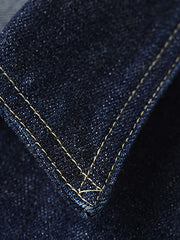 製品画像
1940年代戦時中のS101Jを忠実に再現したリバイバルデニムジャケットの正面デザイン。14オンスのセルビッジデニムとヴィンテージ感溢れるインディゴブルーの色合いが特徴
詳細画像
鉄製の月桂(ゲッケイ)ボタンと真鍮製フライングソーサーリベットのディテール。経年変化による自然な錆びが美しく、クラシックなワークウェアの魅力を引き立てる精密な縫製