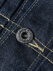 製品画像
1940年代戦時中のS101Jを忠実に再現したリバイバルデニムジャケットの正面デザイン。14オンスのセルビッジデニムとヴィンテージ感溢れるインディゴブルーの色合いが特徴
詳細画像
鉄製の月桂(ゲッケイ)ボタンと真鍮製フライングソーサーリベットのディテール。経年変化による自然な錆びが美しく、クラシックなワークウェアの魅力を引き立てる精密な縫製