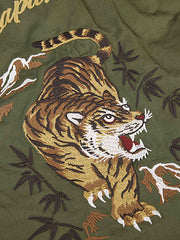 製品画像
リバーシブル仕様のトラ刺繍ワークシャツ全体デザイン。片面には胸元に精緻なトラ刺繍、もう片面には竹林に佇むトラのデザインが施された、オリエンタルデザインとミリタリースタイルが融合したシャツ
詳細画像
胸元に施されたトラ刺繍と銅製ボタンのディテール特写。蘇繍(ソシュウ)の伝統技法による繊細なステッチと、クラシックなミリタリーグリーンキャンバス素材の質感が特徴