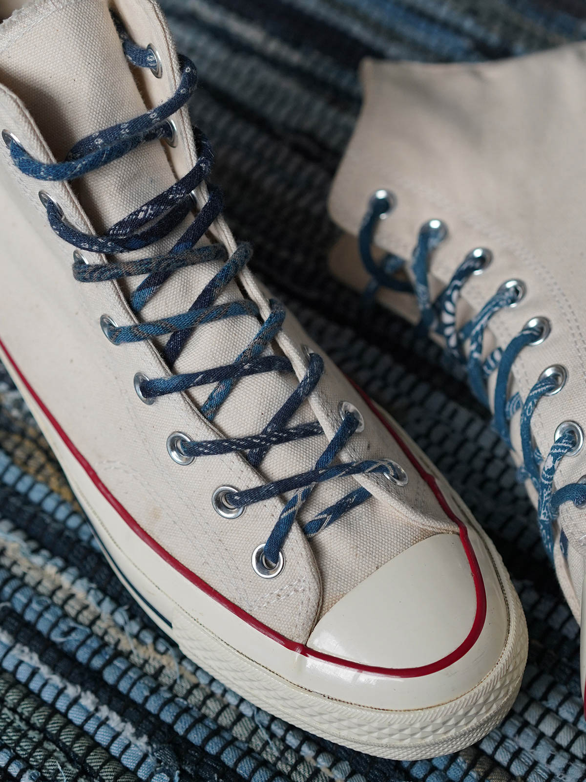 製品画像
「インディゴ染め パッチワーク ヴィンテージ シューレース全体イメージ。藍染め古布を使用し、丸型デザインとヴィンテージ感あふれるパッチワーク技法が特徴。」
細部画像
「金属製シューレースチップと自然な色褪せ感を持つ丸型シューレースのディテールクローズアップ。」