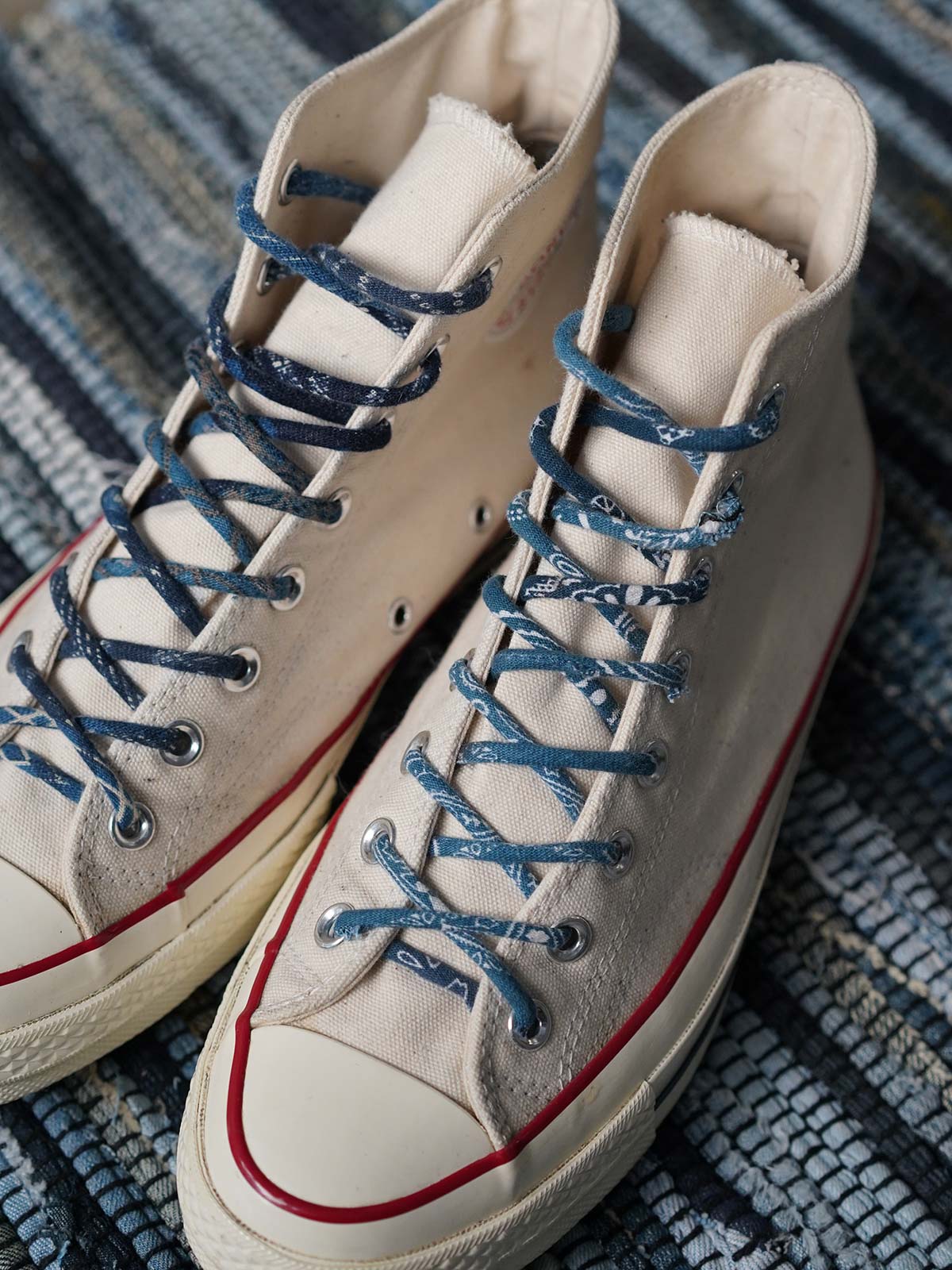 製品画像
「インディゴ染め パッチワーク ヴィンテージ シューレース全体イメージ。藍染め古布を使用し、丸型デザインとヴィンテージ感あふれるパッチワーク技法が特徴。」
細部画像
「金属製シューレースチップと自然な色褪せ感を持つ丸型シューレースのディテールクローズアップ。」