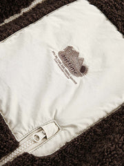 製品画像: リバーシブル シープスキン 中綿ジャケット。柔らかなシープスキンと耐久性のある織りナイロン素材を組み合わせた、多用途デザインの正面全体展示図。
詳細画像: バイカラーデザインと多機能ポケット、さらにハイネック仕様が特徴のリバーシブルジャケットのディテールクローズアップ。