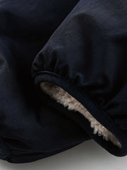 製品画像: リバーシブル シープスキン 中綿ジャケット。柔らかなシープスキンと耐久性のある織りナイロン素材を組み合わせた、多用途デザインの正面全体展示図。
詳細画像: バイカラーデザインと多機能ポケット、さらにハイネック仕様が特徴のリバーシブルジャケットのディテールクローズアップ。