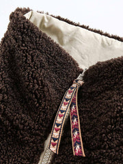 製品画像: リバーシブル シープスキン 中綿ジャケット。柔らかなシープスキンと耐久性のある織りナイロン素材を組み合わせた、多用途デザインの正面全体展示図。
詳細画像: バイカラーデザインと多機能ポケット、さらにハイネック仕様が特徴のリバーシブルジャケットのディテールクローズアップ。