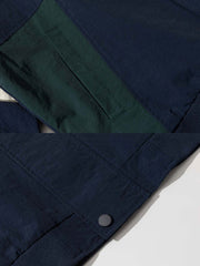 製品画像
「スタイリッシュなバイカラーパッチデザインが特徴のスポーツジャケット全体展示図。現代的なスポーツスタイルとヴィンテージ要素が融合し、独特で個性的な雰囲気を演出。」
詳細画像
「胸元の精巧な刺繍ロゴと袖口リブのディテール特写。リブが防風性と保温性を高め、全体のデザインが質感を引き立てています。」