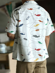 モデルが鯉プリントのハワイアンシャツを着用し、夏のカジュアルスタイルを披露。